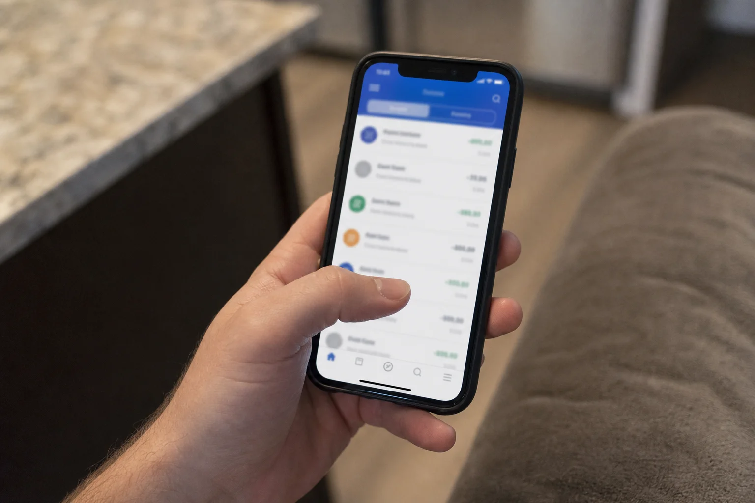 Hand som håller en telefon med bankapp öppen för att sänka fasta kostnader